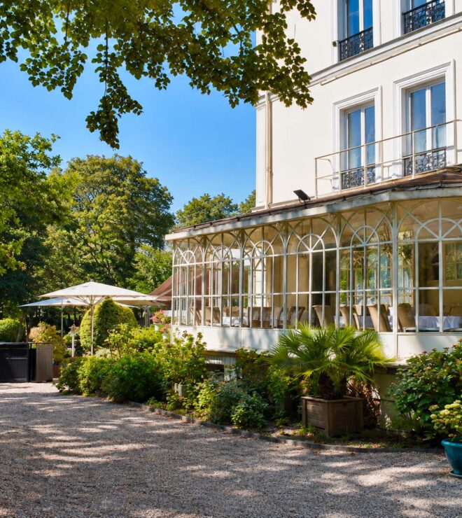 The glass veranda of La Vieille Fontaine restaurant in Maisons-Laffitte, a bright dining room opening onto the garden