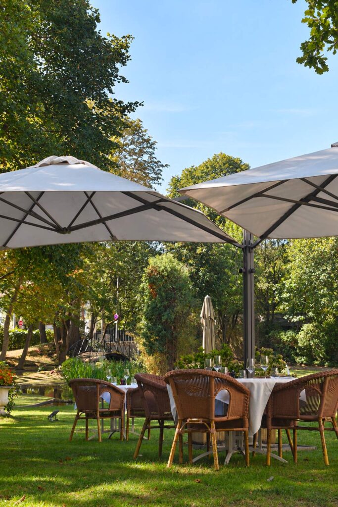 Les tables sous les parasols dans le jardin