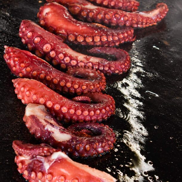 Tentacule de poulpe en cuisson au brasero du restaurant La Vieille Fontaine à Maisons-Laffitte, grillé au feu de bois