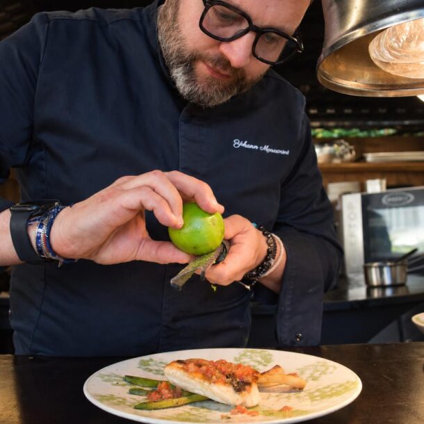 Le chef zeste un citron vert sur un poisson grillé et ses asperges, à La Vieille Fontaine à Maisons-Laffitte