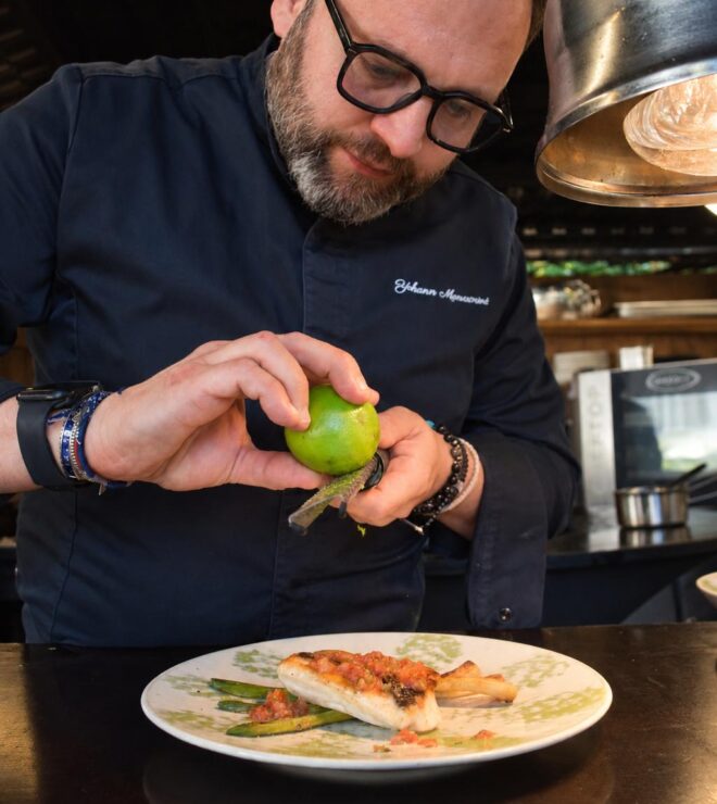 The chef zesting a lime over grilled fish and asparagus at La Vieille Fontaine in Maisons-Laffitte