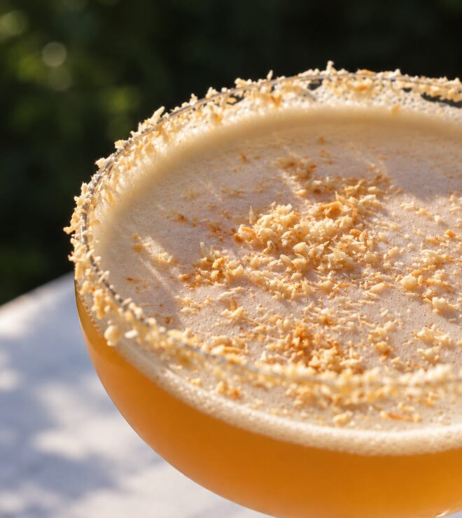 House cocktail with a toasted coconut rim, served on the terrace at La Vieille Fontaine in Maisons-Laffitte